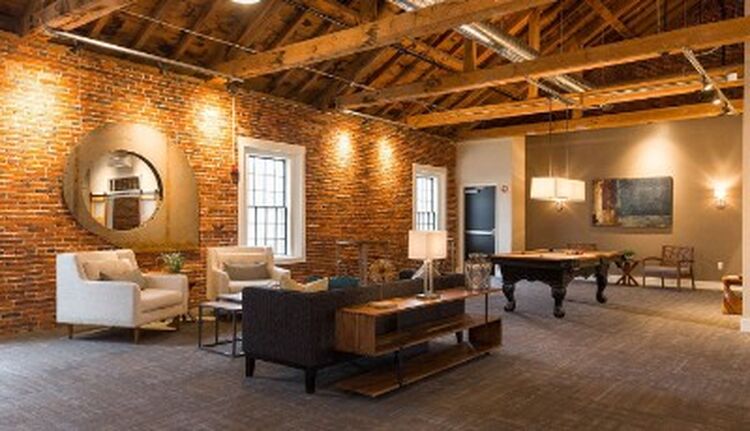 El proyecto del Exeter Club Room transformó un edificio centenario en deterioro, que durante décadas se utilizó como almacén y área de mantenimiento, en un lujoso espacio comunitario para los residentes de los 161 apartamentos del Exeter Mill. El dis Exeter Club Room